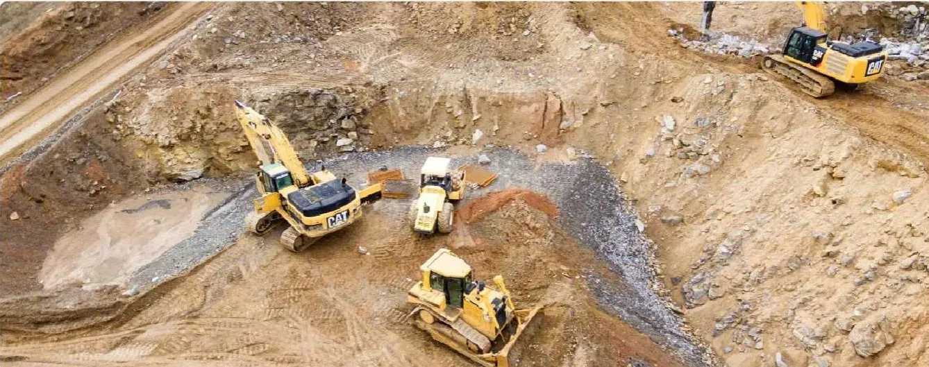 Faena de movimiento de tierra con excavadoras y bulldozer trabajando en un corte de cerro